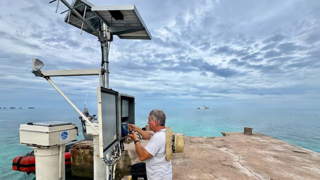 A NOAA technician aboard the U.S. Coast Guard Cutter Oliver Henry works to restore a critical tsunami early warning station on a remote Pacific atoll in March 2026. (Photo Credit: U.S. Coast Guard)