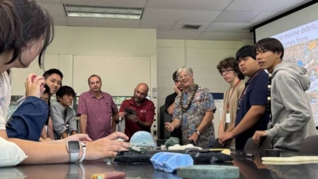 Dr. Steve Colbert, a marine scientist at the University of Hawaiʻi at Hilo, works with students to identify trash from Japan that floated to Hawaiʻi. (Courtesy of Hawaiʻi International Science Experience) 