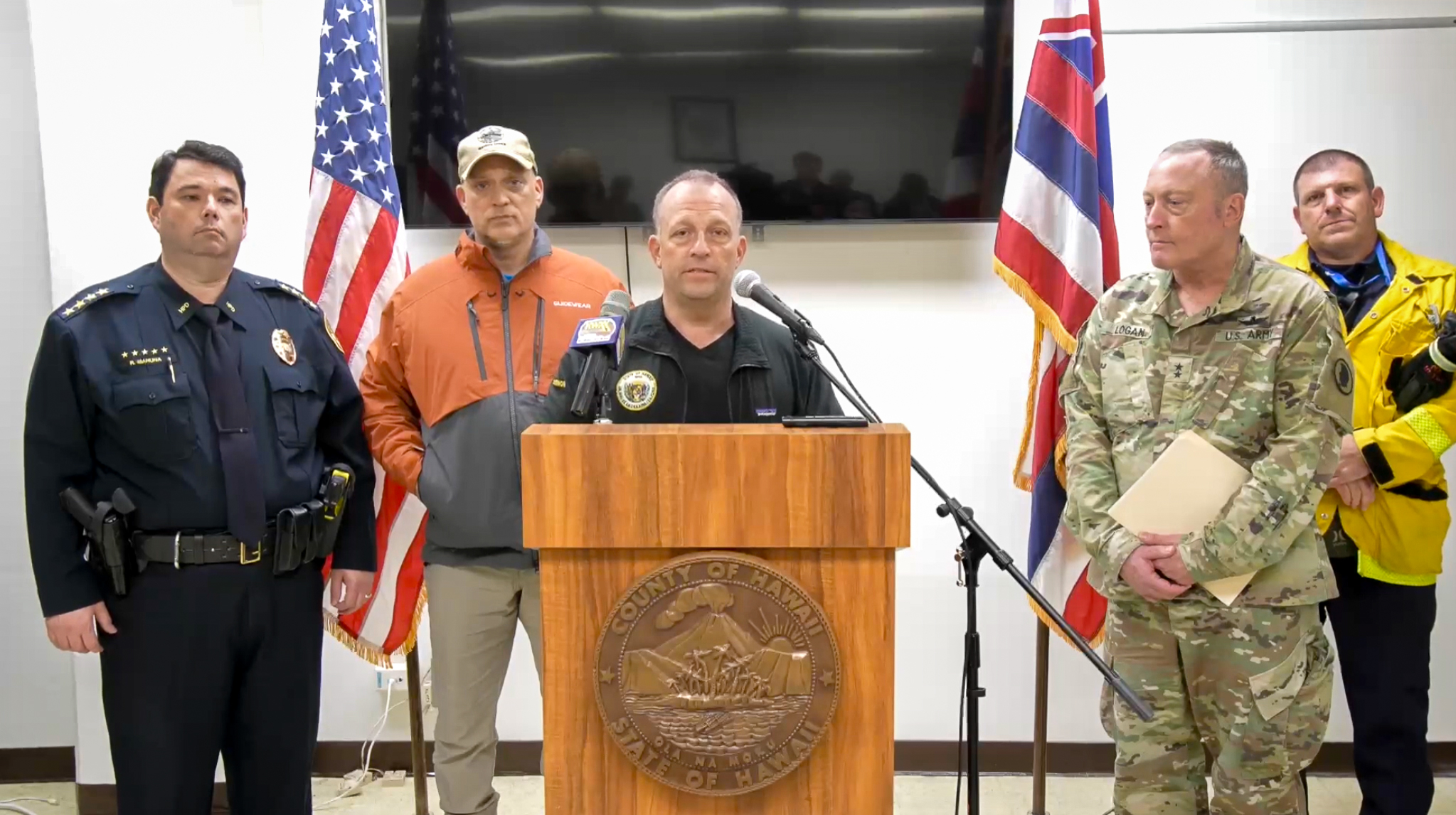 Hawaiʻi Gov. Josh Green talks about recovery from Hurricane Lala, while flanked by Hawaiʻi Police Chief Reed Mahuna, Mayor Kimo Alameda, Major General Stephen F. Logan and temporary fire chief Daniel Volpe during a press conference on Aug. 17, 2026 in HIlo. (Screenshot: Hawaiʻi County video)
