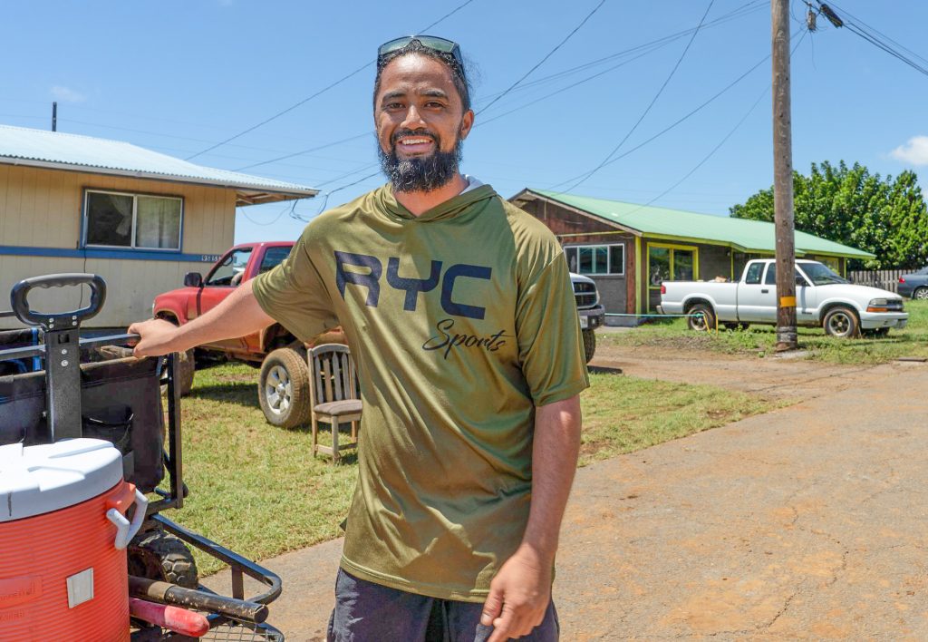 Kana Mook makes a delivery of water and food on Poha Street in Nā‘ālehu on Aug. 19, 2026, following Hurricane Lala. (Tiffany DeMasters/Big Island Now)