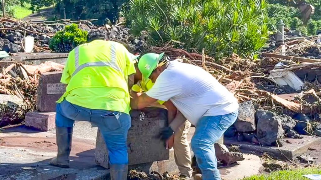 Isemoto Contracting workers help Zed Ka‘apana Aki place great-grandmother's headstone back on slab after it was broken during Hurricane Lala. (Photo courtesy: Zed Ka‘apana Aki) 