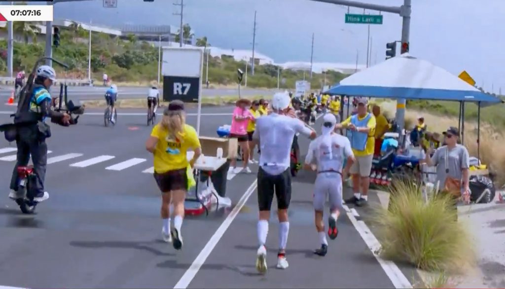 With 4.7 miles to go in the 140.2-mile Ironman World Championship, Vincent Luis of France passed longtime race leader Magnus Ditlev of Denmark at an aid station on Oct. 10, 2026. (Screenshot Ironman video)